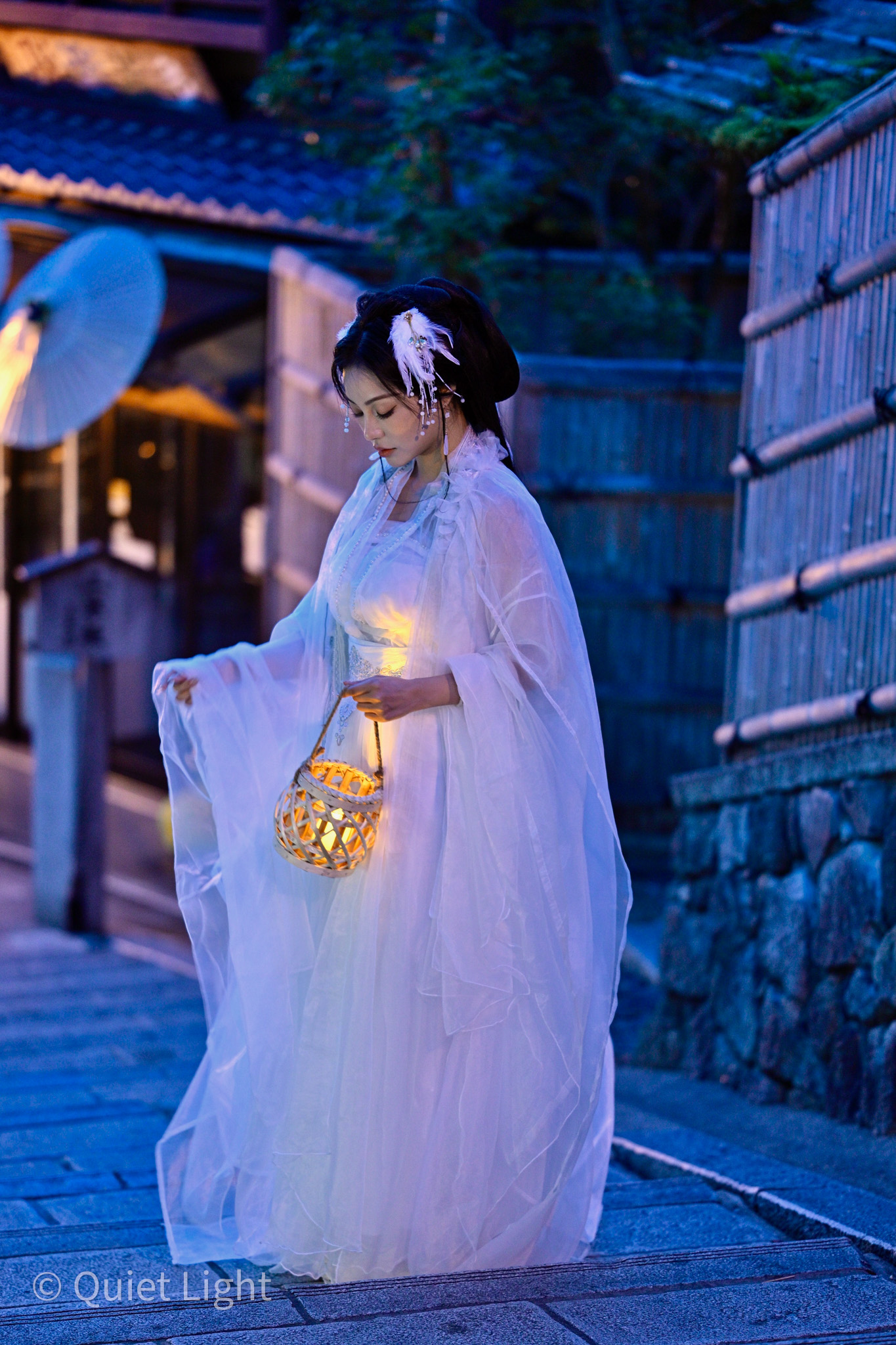 Close portrait with warm lantern light on the model's face.